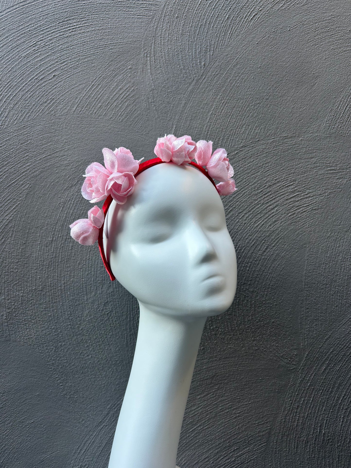 Handcrafted pale pink blossoms headpiece made from vintage millinery fabric, set on a contrasting red headband - perfect for race day fashion and spring carnival styling.