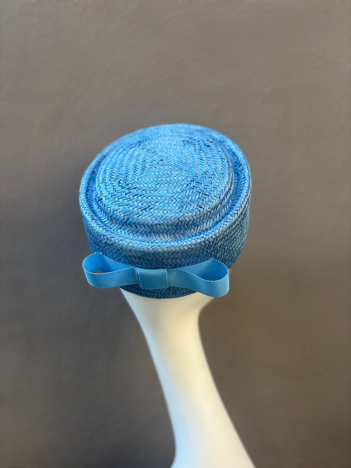 Blue pillbox hat featuring a statement bow detail. Handcrafted for weddings, racewear and special occasions.