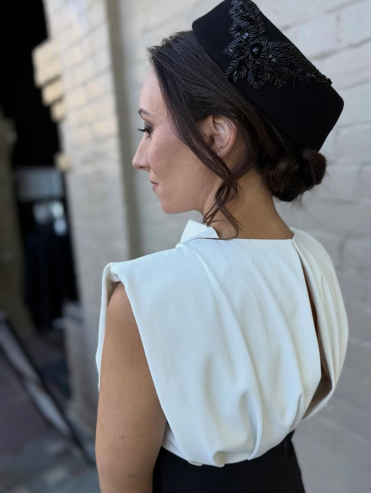 Katelyn McDonald wearing a black felt pillbox hat, classic racewear millinery.